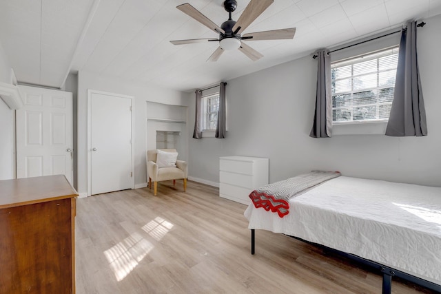 bedroom featuring ceiling fan, light wood finished floors, and baseboards