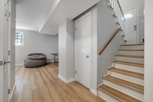 stairs with wood finished floors and baseboards