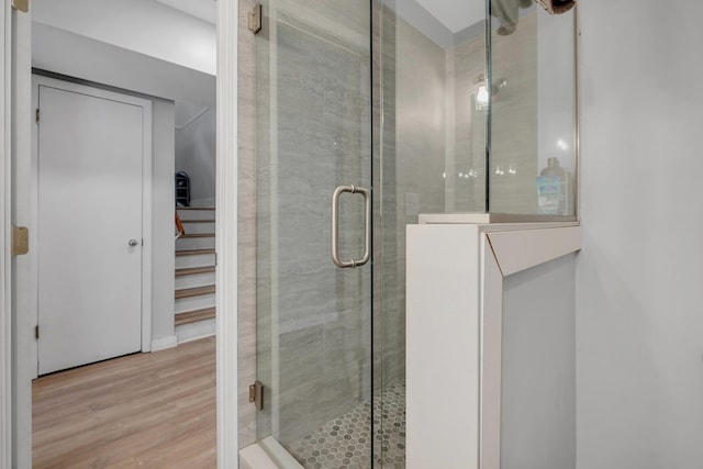 full bath featuring a shower stall and wood finished floors