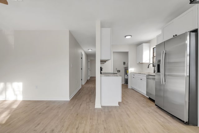 1115 Joe Louis St, Tallahassee, FL 32304 - kitchen featuring stainless steel appliances, light countertops, light wood-style flooring, white cabinetry, and electric water heater