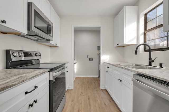 1115 Joe Louis St, Tallahassee, FL 32304 - kitchen featuring appliances with stainless steel finishes, white cabinets, and light wood-type flooring