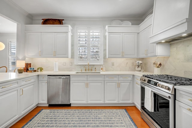 kitchen featuring appliances with stainless steel finishes, sink, white cabinets, and decorative backsplash