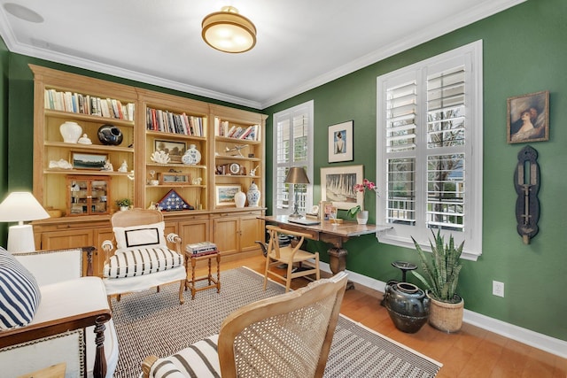 sitting room with ornamental molding and light hardwood / wood-style floors