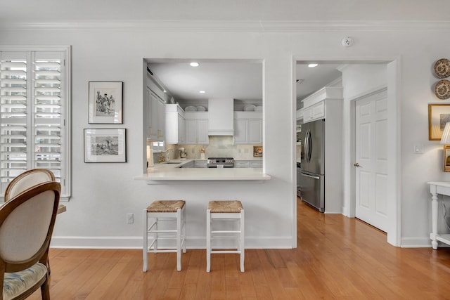 kitchen featuring light wood-type flooring, appliances with stainless steel finishes, sink, and white cabinets