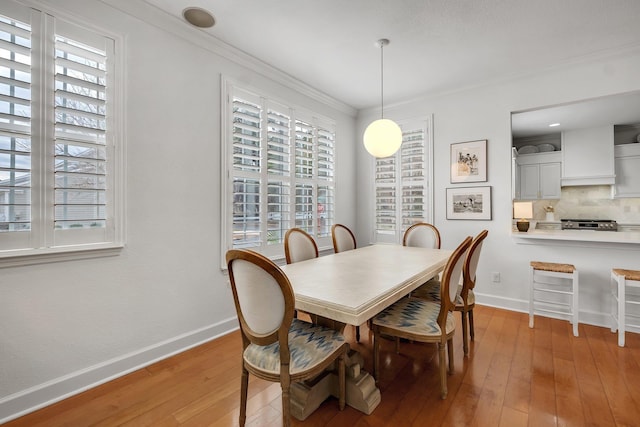 dining room with light hardwood / wood-style flooring and ornamental molding