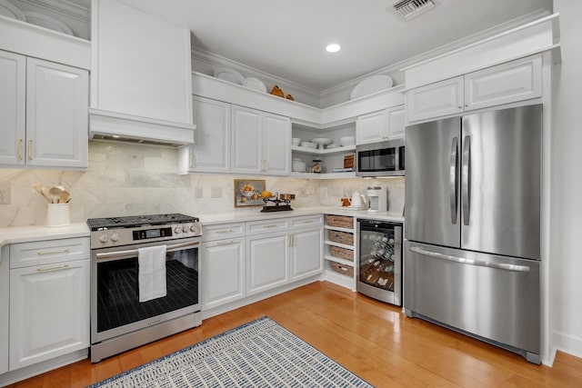 kitchen with backsplash, stainless steel appliances, beverage cooler, and white cabinets