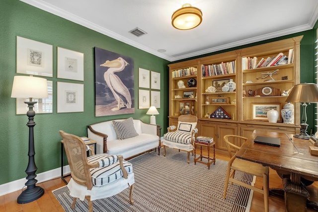 living area with hardwood / wood-style flooring and crown molding