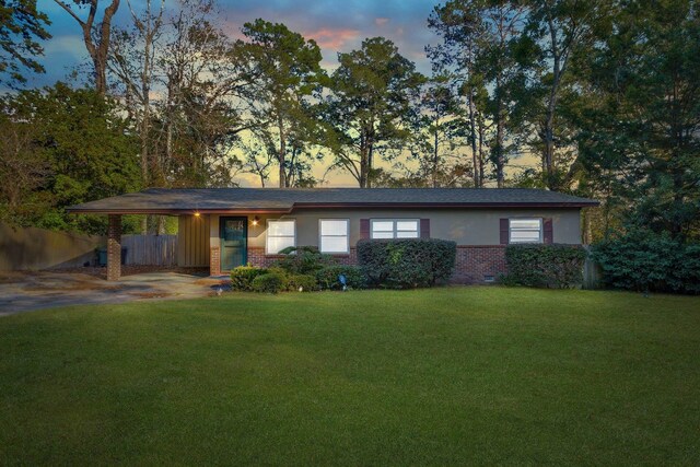 single story home with a carport and a lawn