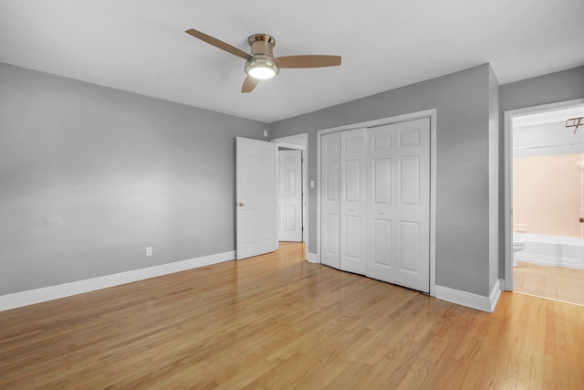 unfurnished bedroom featuring a closet, ceiling fan, ensuite bathroom, and light hardwood / wood-style floors