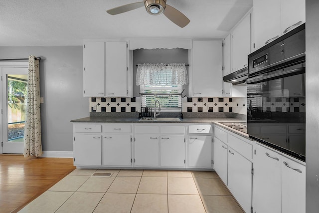 kitchen featuring sink, white cabinets, and black appliances