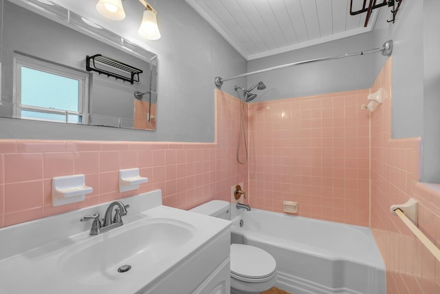 full bathroom featuring ornamental molding, vanity, tile walls, toilet, and tiled shower / bath