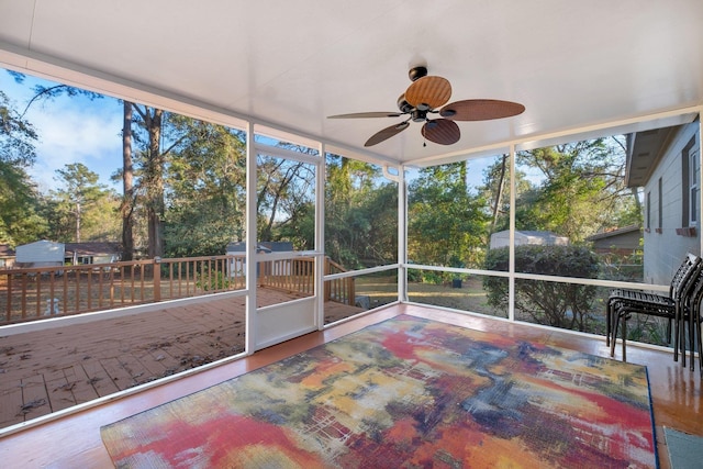 unfurnished sunroom with ceiling fan