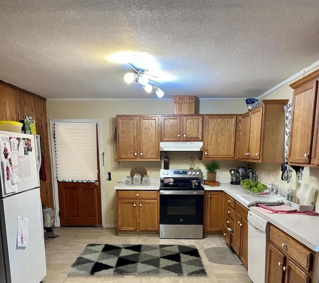 kitchen with white appliances, a textured ceiling, light tile patterned flooring, crown molding, and sink