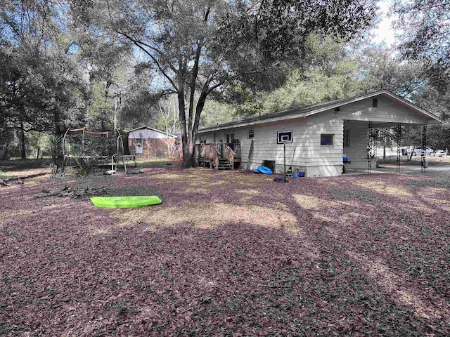 view of yard with a trampoline and a wooden deck