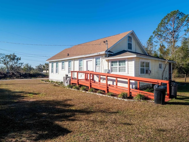 rear view of property featuring a lawn and a wooden deck