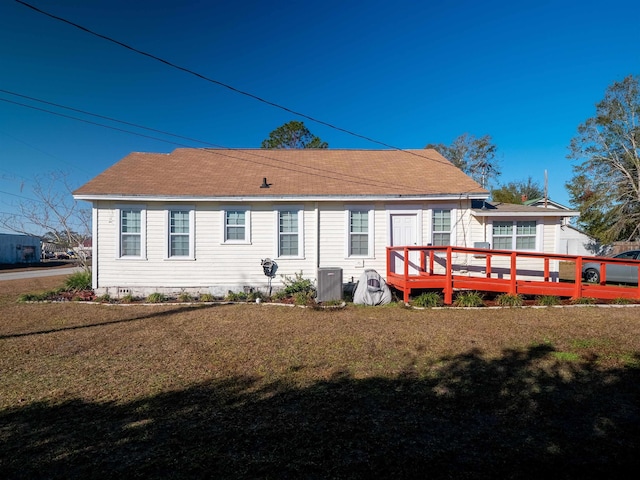 back of property featuring a lawn, cooling unit, and a wooden deck