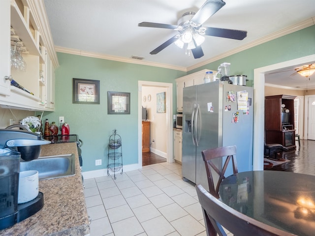 kitchen featuring crown molding, light tile patterned floors, and stainless steel fridge with ice dispenser