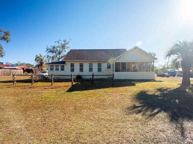 ranch-style house featuring a front lawn and a sunroom