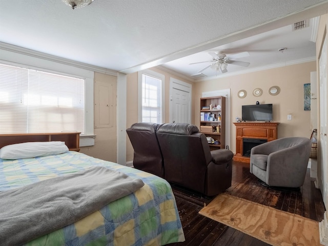 bedroom with a textured ceiling, dark hardwood / wood-style floors, a closet, ceiling fan, and ornamental molding