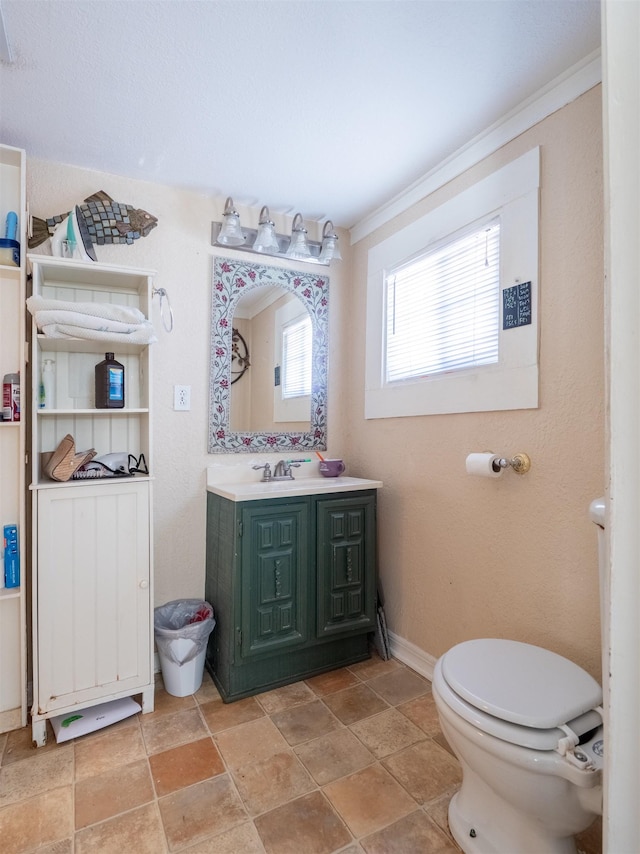 bathroom featuring toilet, crown molding, and vanity