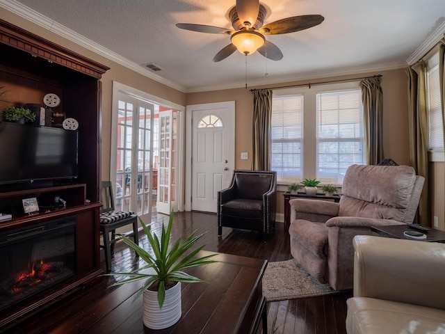 living room with ornamental molding, ceiling fan, dark hardwood / wood-style flooring, and a textured ceiling