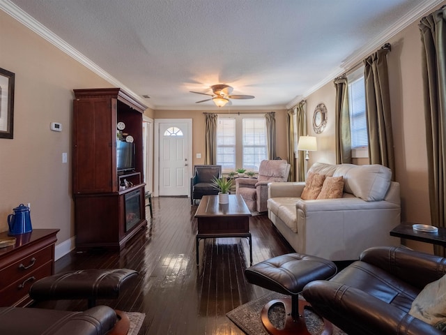 living room with crown molding, ceiling fan, dark wood-type flooring, a fireplace, and a textured ceiling