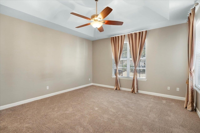spare room with ceiling fan, light colored carpet, and baseboards