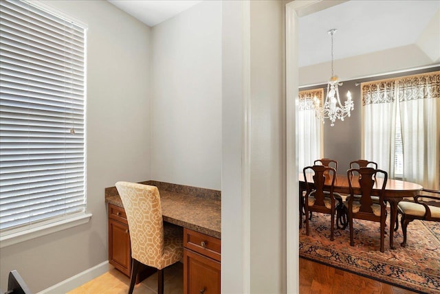 office space featuring built in study area, an inviting chandelier, baseboards, and light tile patterned flooring