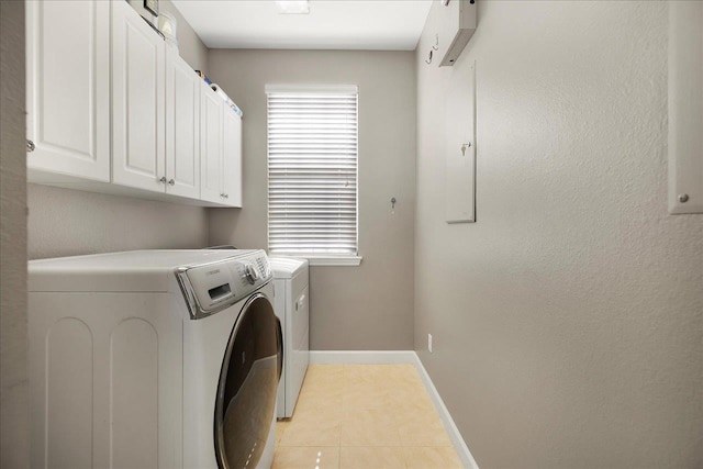 washroom with cabinets, light tile patterned floors, and washer and clothes dryer