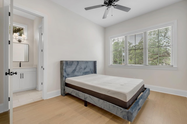 1261 N Duval St, Tallahassee, FL 32303 - bedroom featuring baseboards, light wood-style flooring, ensuite bath, a sink, and a ceiling fan