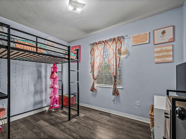 bedroom featuring visible vents, baseboards, and wood finished floors