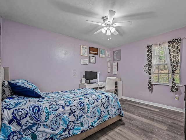 bedroom with visible vents, wood finished floors, baseboards, and ceiling fan