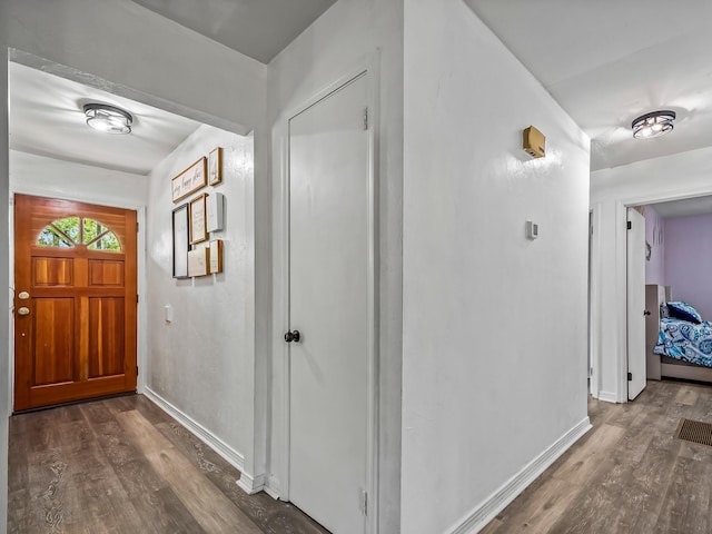 entryway featuring baseboards and dark wood-style flooring