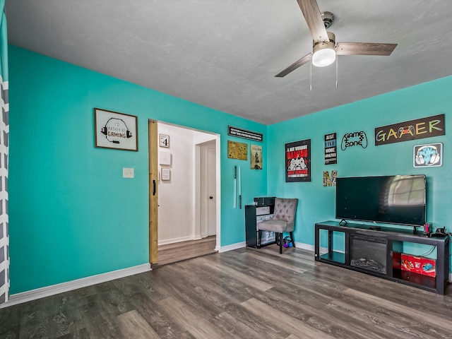 sitting room featuring ceiling fan, baseboards, and wood finished floors