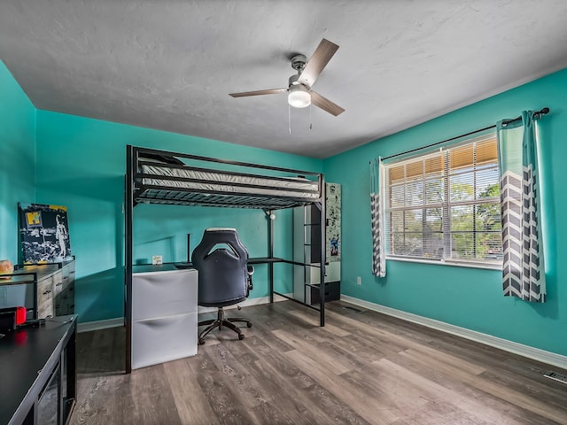 bedroom with baseboards, wood finished floors, and a ceiling fan