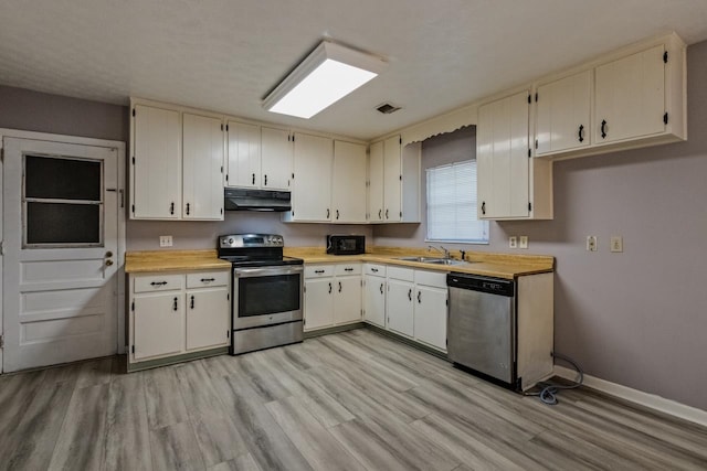 405 Mercury Dr, Tallahassee, FL 32305 - kitchen with stainless steel appliances, extractor fan, light wood-style flooring, and light countertops