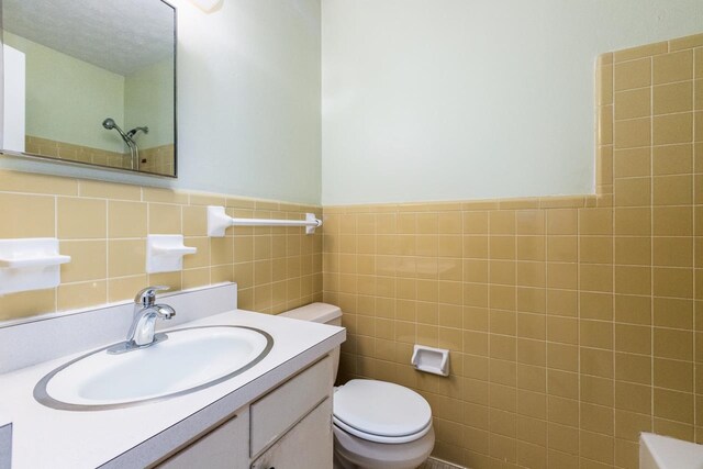 405 Mercury Dr, Tallahassee, FL 32305 - bathroom with tile walls, vanity, a shower, and a wainscoted wall