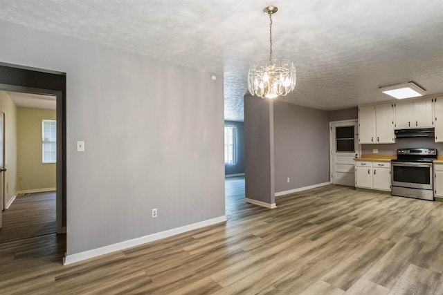 405 Mercury Dr, Tallahassee, FL 32305 - kitchen featuring stainless steel range with electric stovetop, a chandelier, under cabinet range hood, a textured ceiling, and light countertops