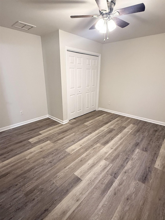 unfurnished bedroom featuring a closet, ceiling fan, and dark hardwood / wood-style floors