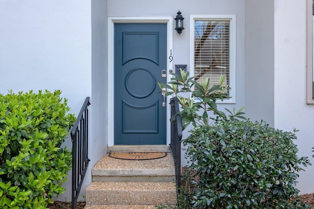 doorway to property featuring stucco siding