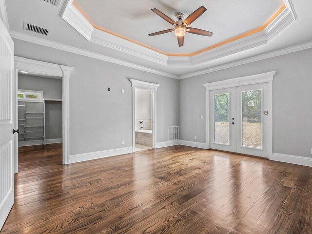 interior space featuring ceiling fan, visible vents, wood finished floors, and a raised ceiling
