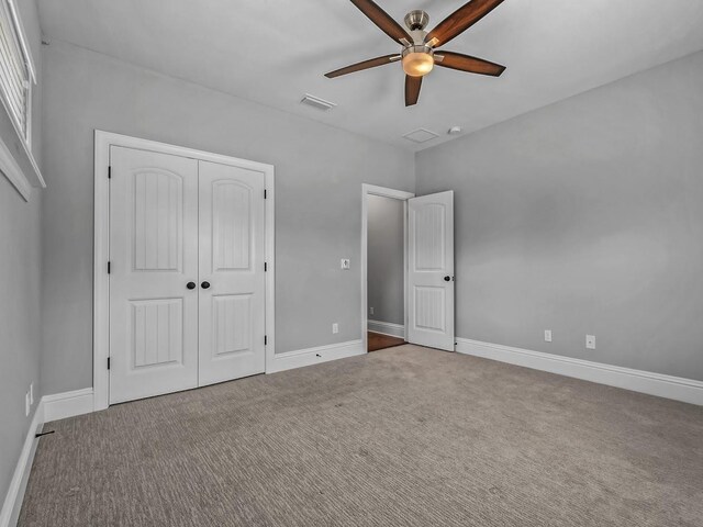 unfurnished bedroom featuring baseboards, carpet, a closet, and visible vents
