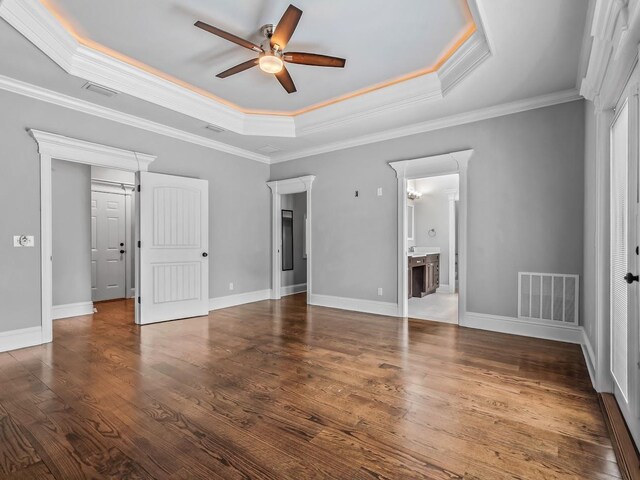unfurnished bedroom with visible vents, ornamental molding, and a tray ceiling