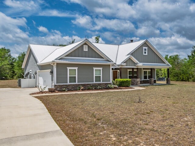 craftsman inspired home featuring board and batten siding, covered porch, stone siding, and concrete driveway