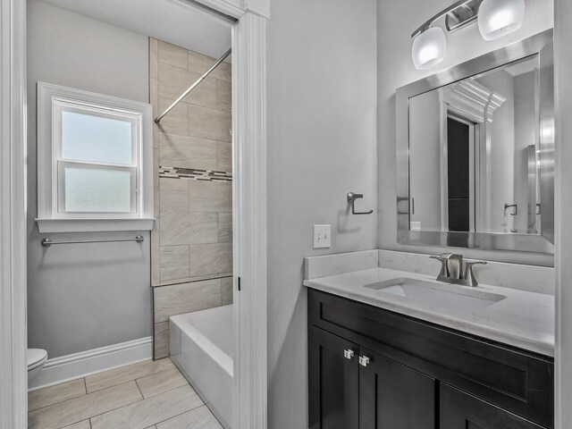 full bathroom with vanity, baseboards, bathtub / shower combination, and toilet
