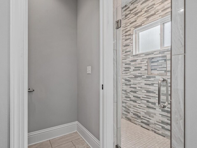 full bathroom with baseboards and a stall shower