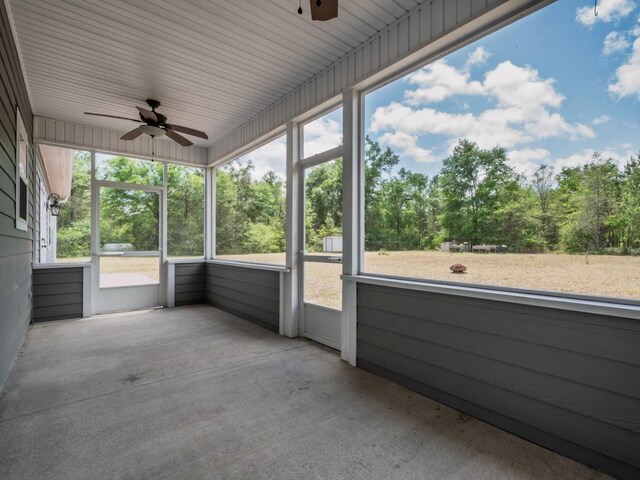 unfurnished sunroom with a ceiling fan