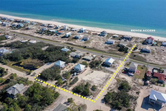 birds eye view of property with a water view and a beach view