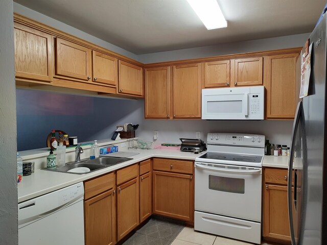 kitchen with sink, white appliances, and light tile patterned floors