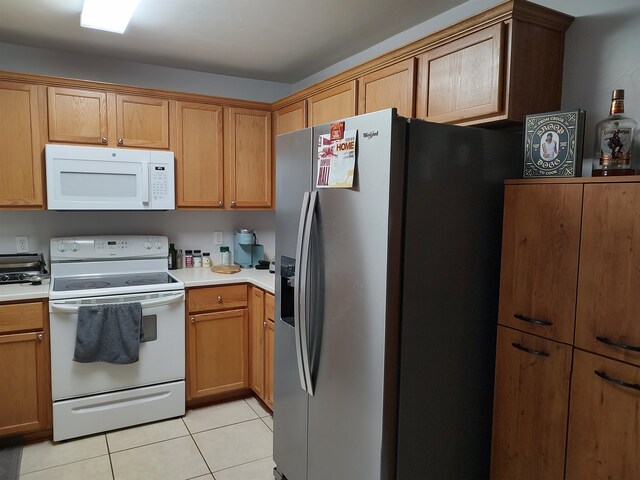 kitchen with white appliances and light tile patterned flooring